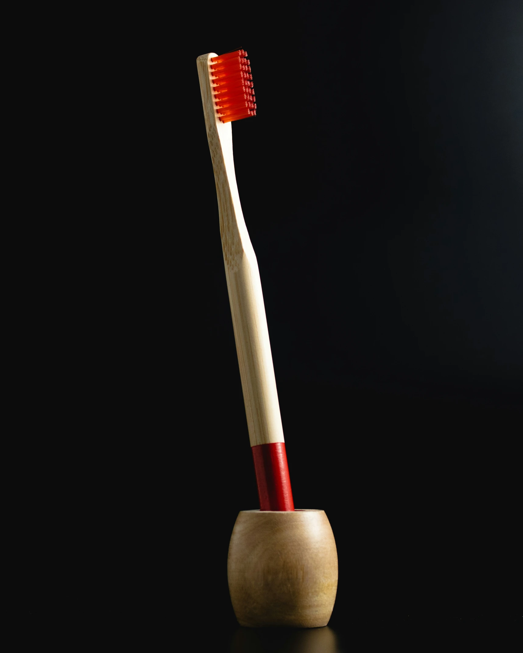 two toothbrushes on a wooden stand that has red and white stripes on it
