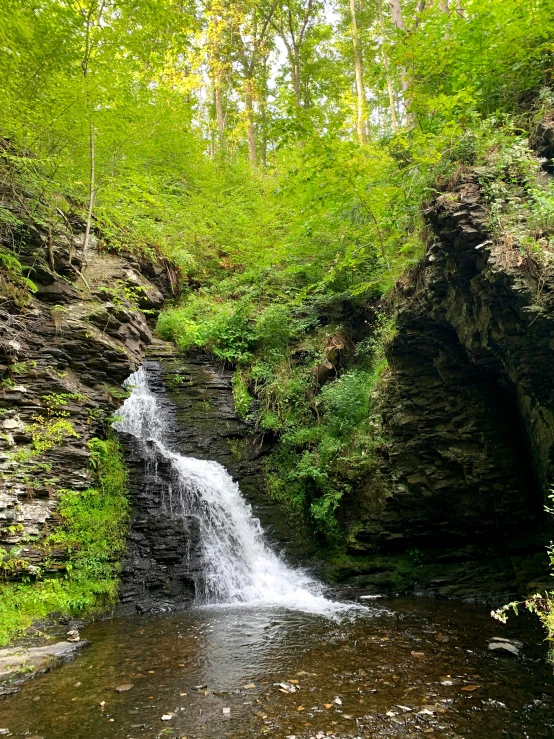 the waterfall has a long pool of water running under it