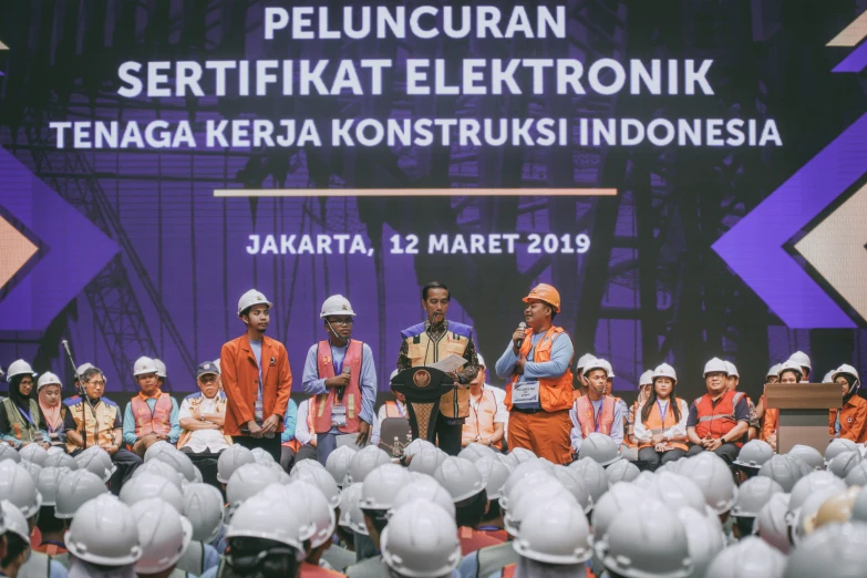 a large group of construction workers standing in front of helmets