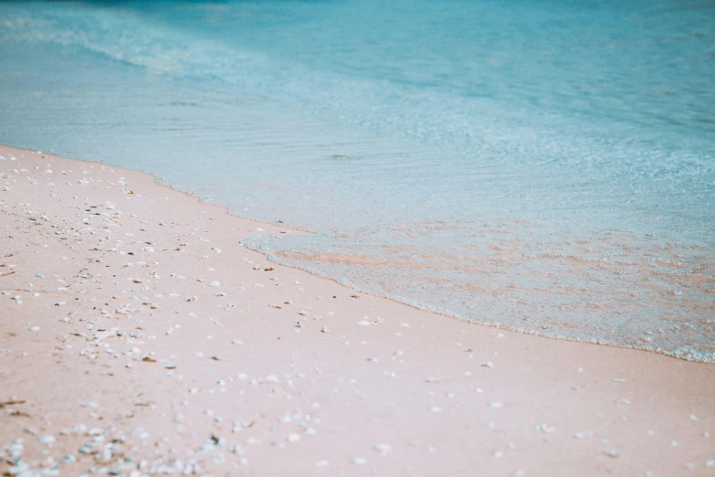 white sand and blue water on the shore of a beach