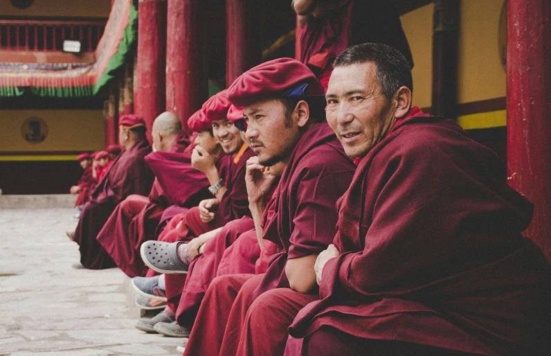 monks sitting in rows together, posing for the camera