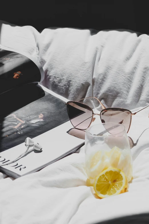 a glass cup with oranges sits on top of a bed