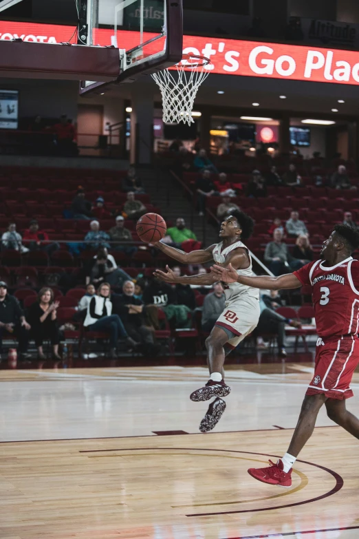 two people in uniforms are playing basketball on a court