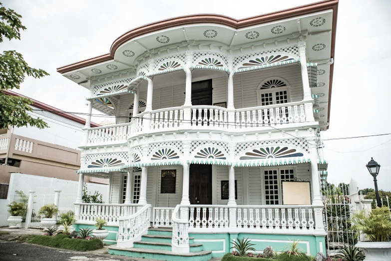 a multi story house with two balconies in front of it