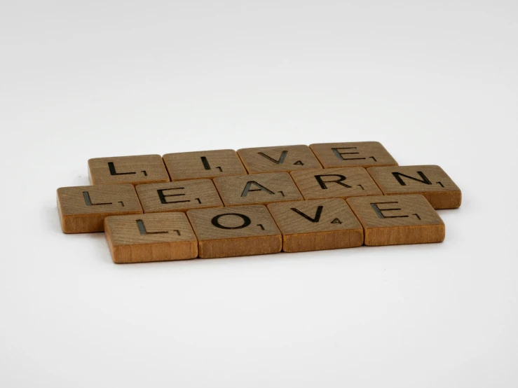 three cork tiles spelling live, learn, love