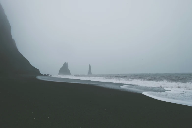 a black sand beach covered in heavy rain