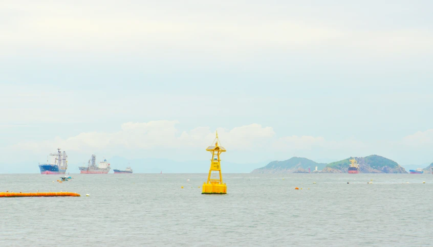 two yellow poles on the sea with boats