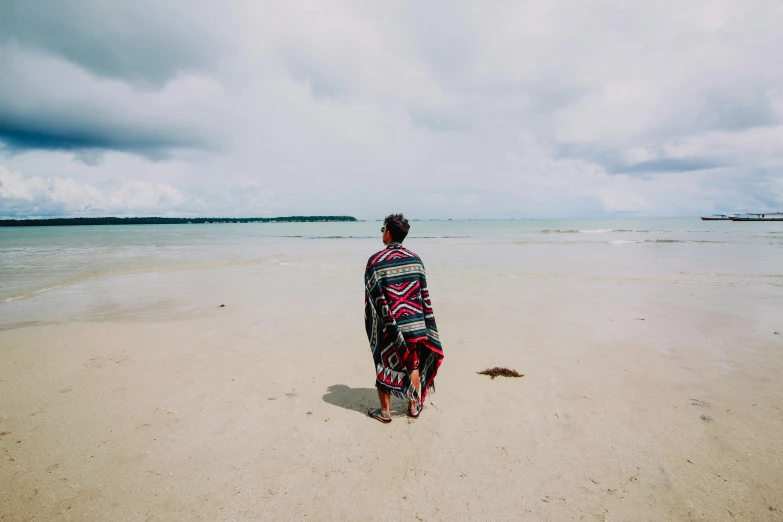 the person is standing in the sand by the water