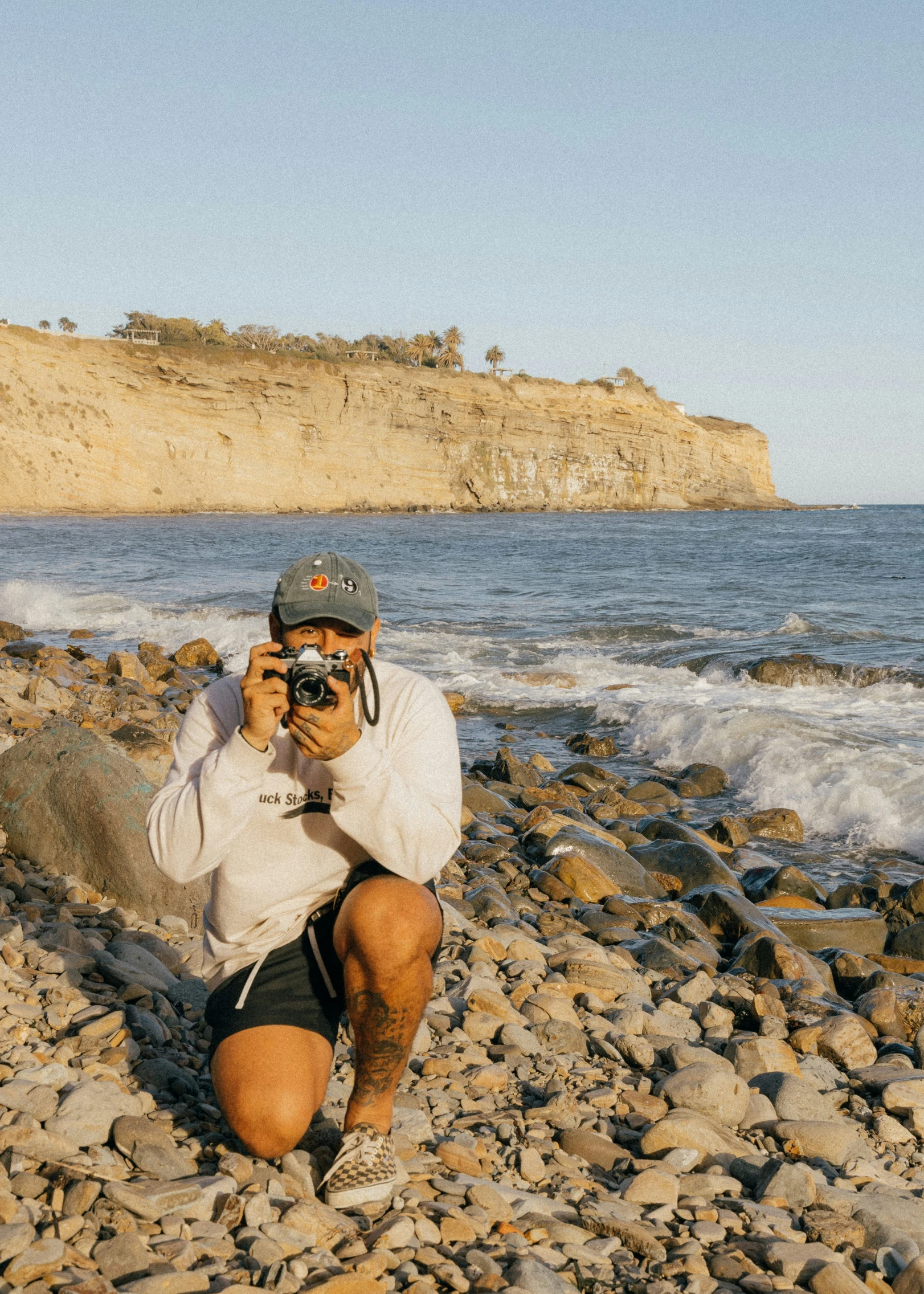 a man on the beach with a camera taking a picture