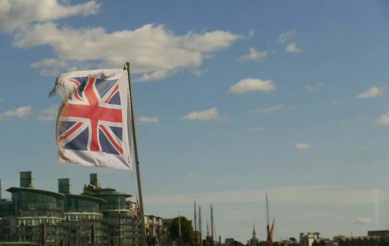 a large british flag flying in front of a blue sky