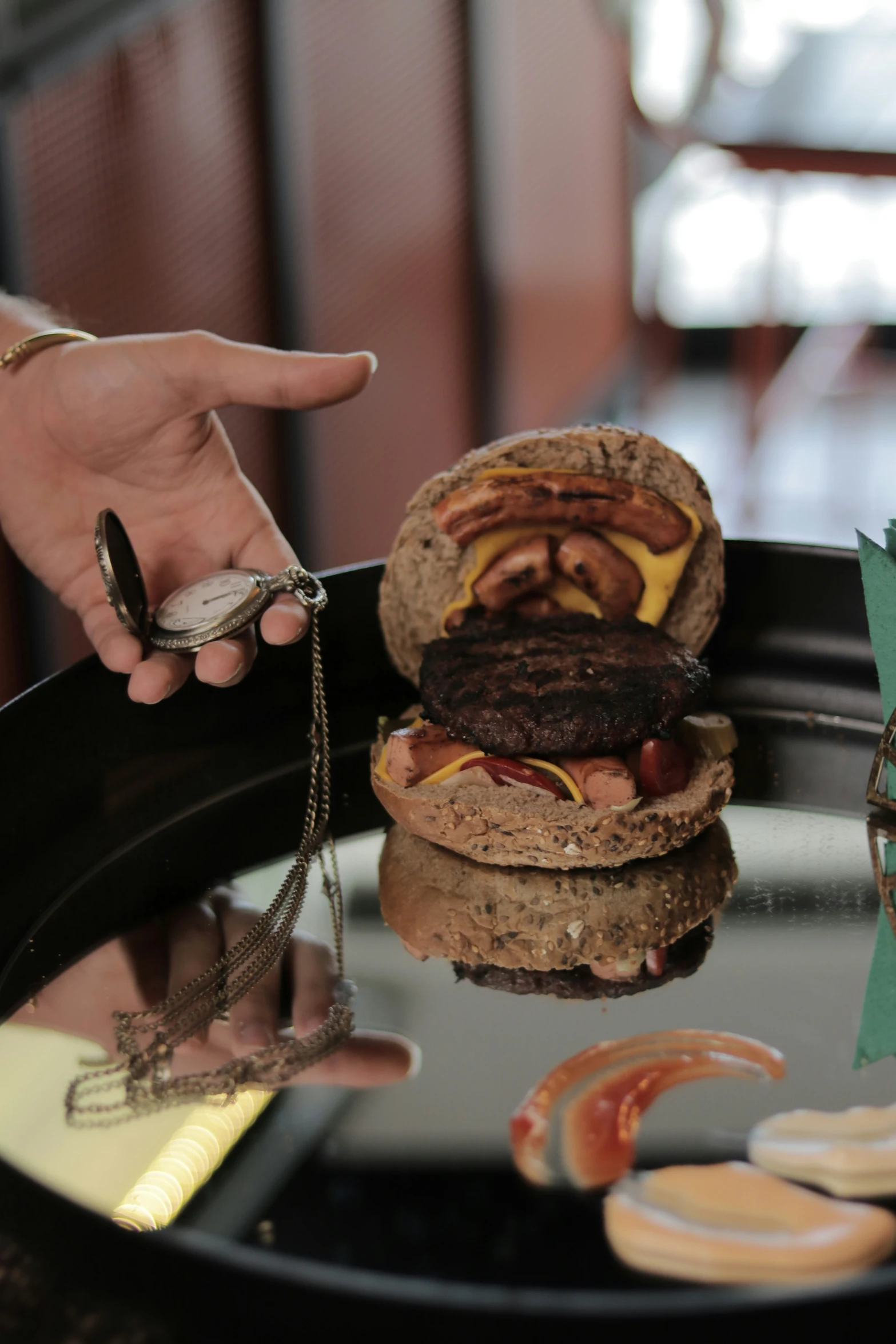 there is a hamburger on the table by someone holding it up