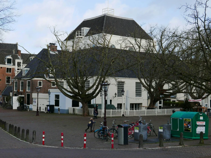 several bicycles parked on a brick and cement street with houses