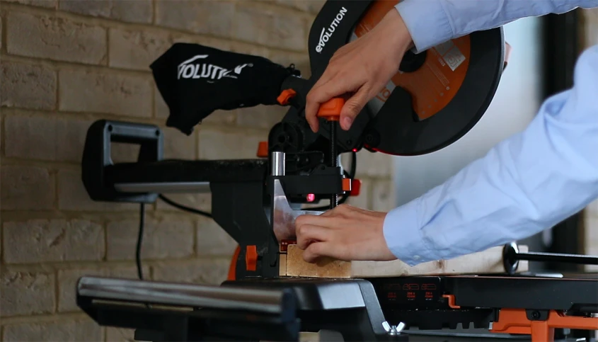 a hand holding an object while another person adjusts the tripod