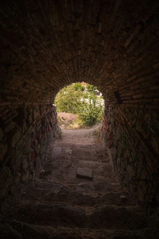 an open archway between two concrete walls, with grass behind