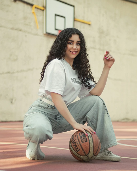 a girl is holding up a basketball