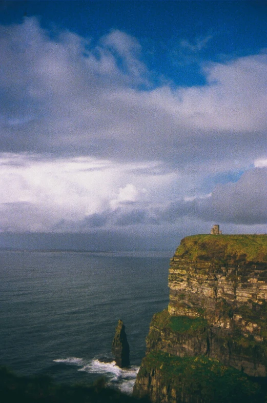 a lighthouse in the middle of some cliffs with waves