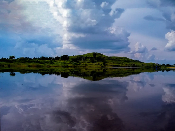 a large body of water with a small hill in the distance