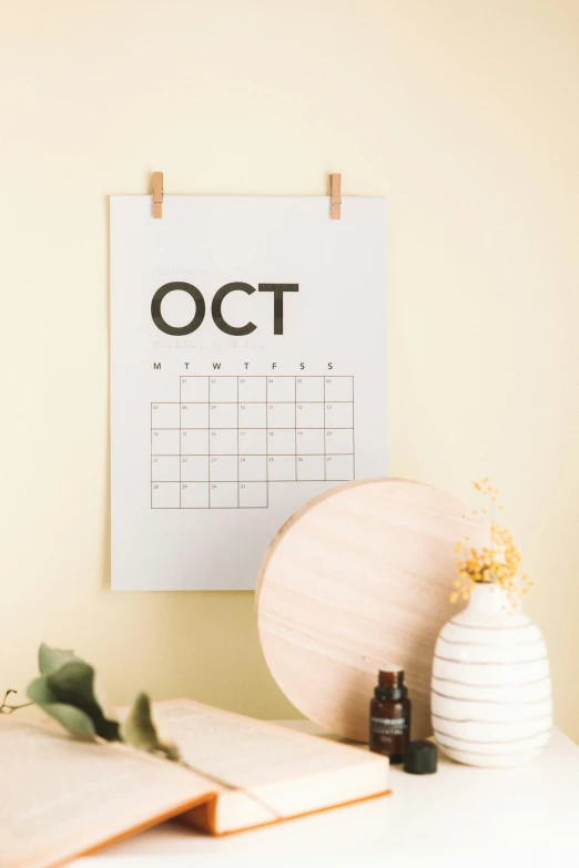 an orange flower in vase next to a cork board and notepad