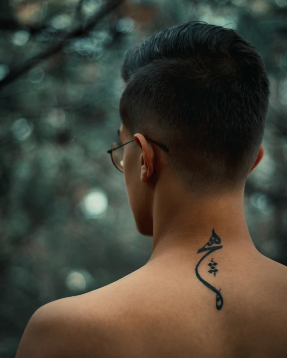 a person with a black ink tattoo on their back