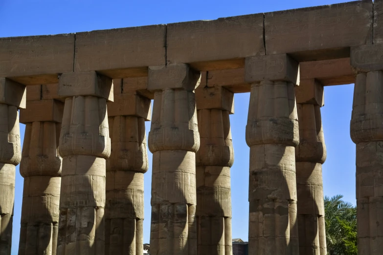 a row of large stone statues against a blue sky