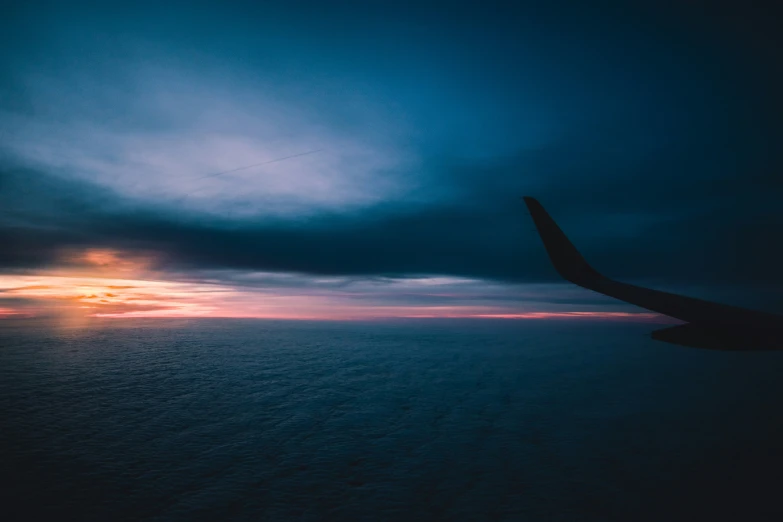 the view from an airplane window of the setting sun