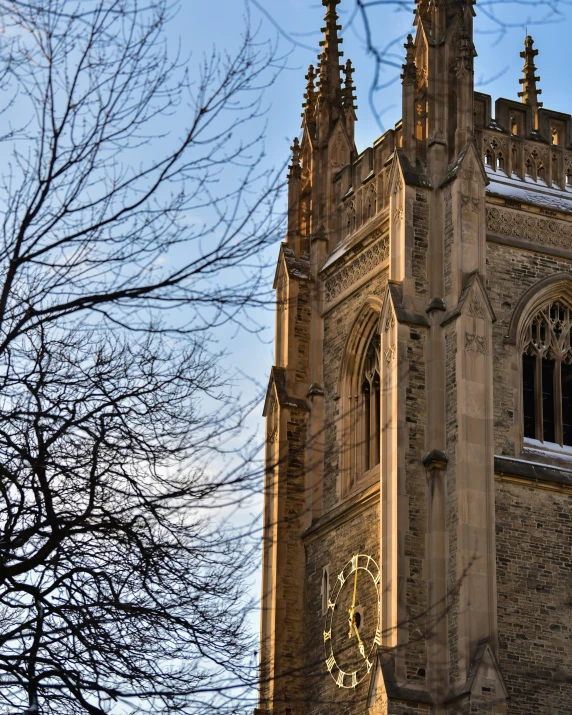 the tower of an old church has a clock displayed on it