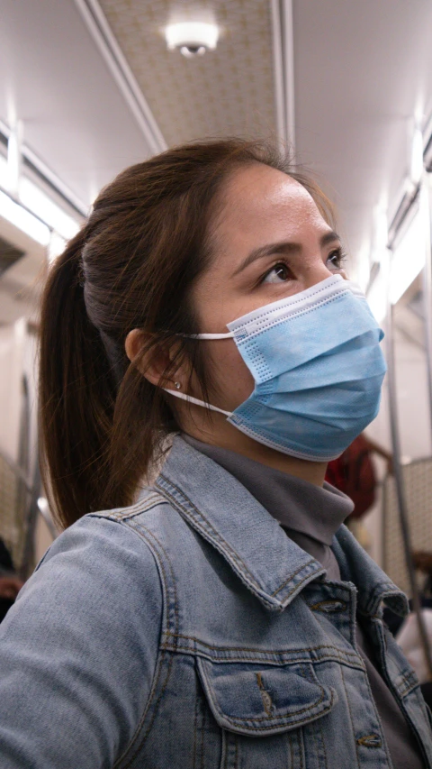 woman in denim jacket wearing a surgical mask