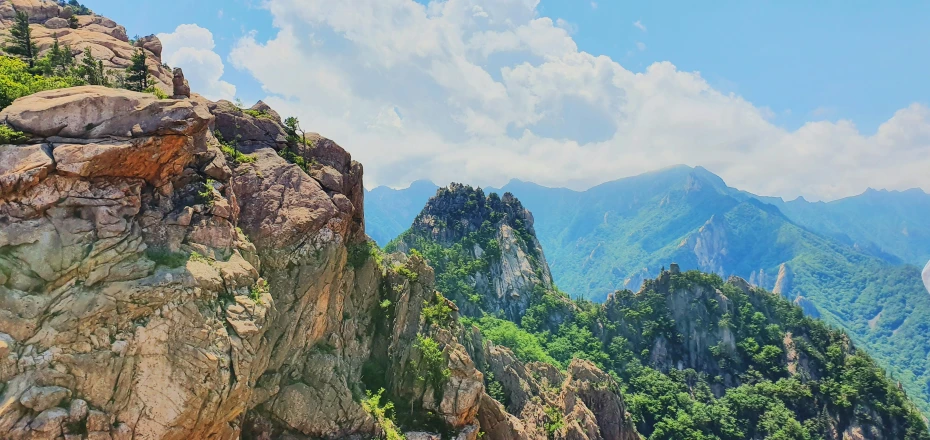 a mountainous landscape with mountain tops with clouds in the sky