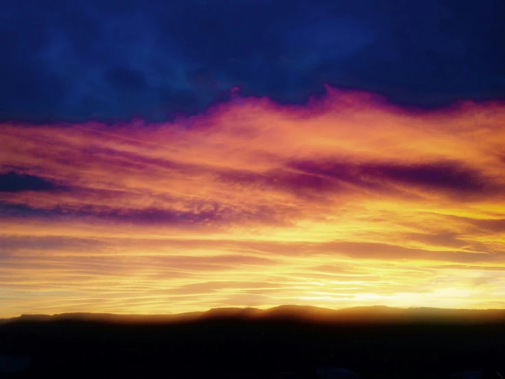 sunset with several pink and orange clouds on dark blue sky