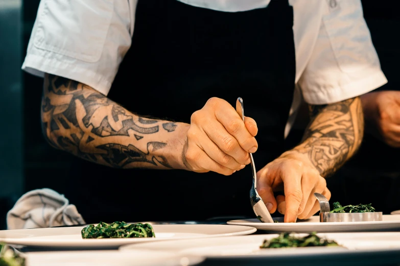 a person slicing vegetables on plates while someone else cuts them