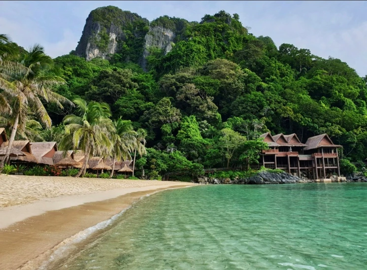 an empty beach and a row of els at the shore of a tropical resort