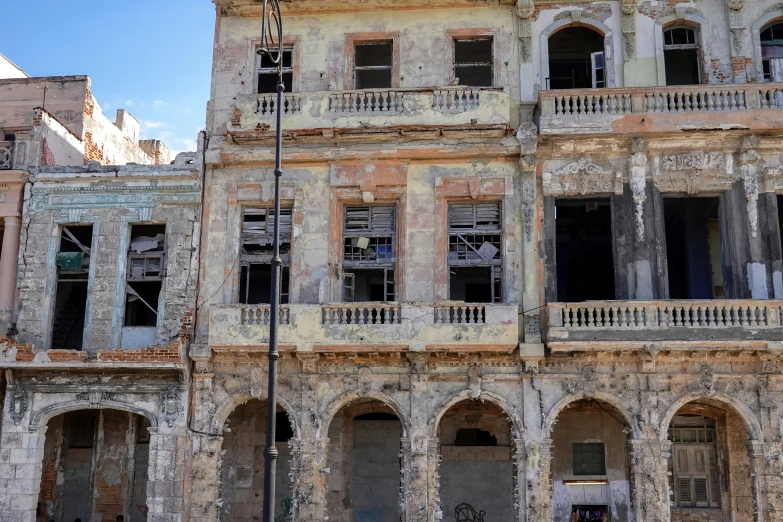 an old building with broken windows and balconies