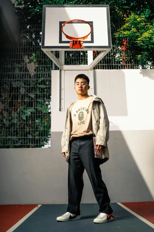 a young man standing next to a basketball court