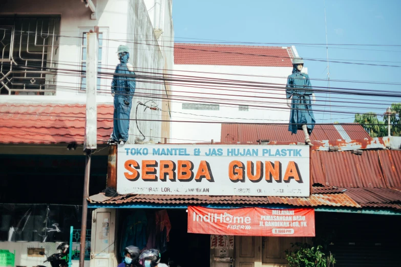 a large banner of two statues in the middle of a street
