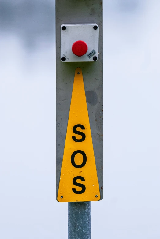 a sign is attached to a pole with a red light