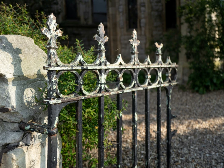 a white stone wall with a wrought iron gate