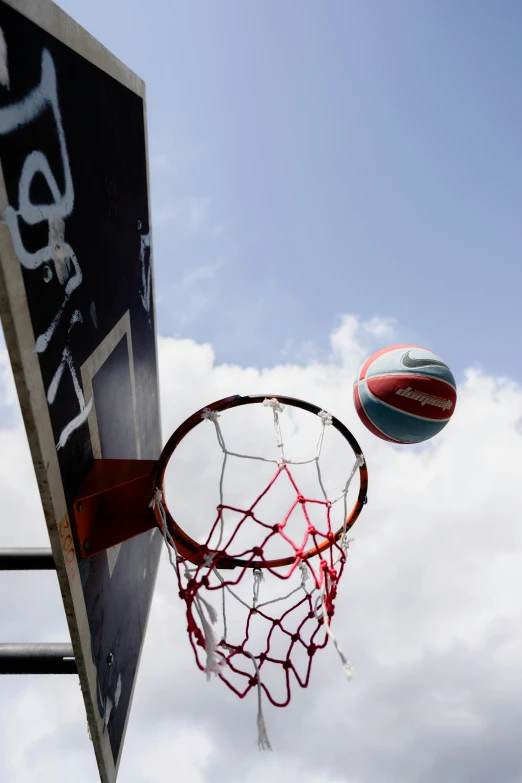 an outdoor basketball hoop with a blue and red ball