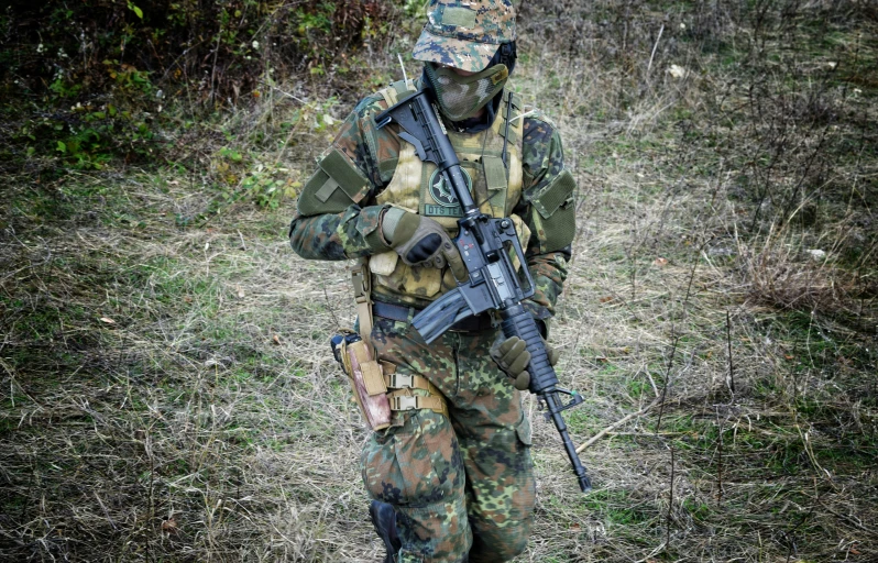 a soldier with his rifle and camouflage gear