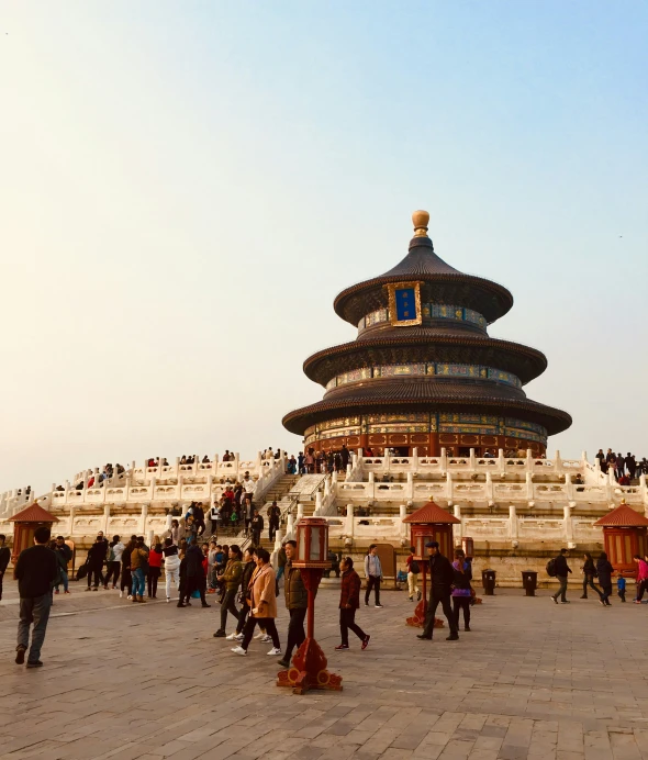 a large group of people walking around the temple