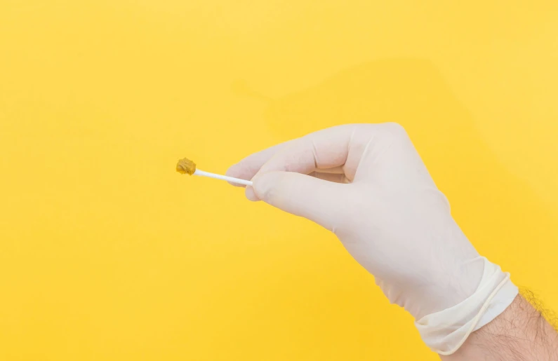 a man holding an electronic cigarette on a yellow background