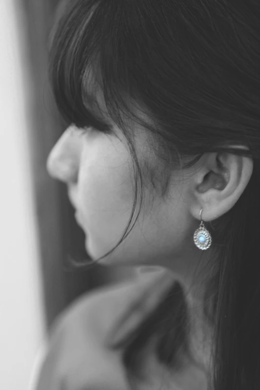 a young woman wearing a pair of earrings