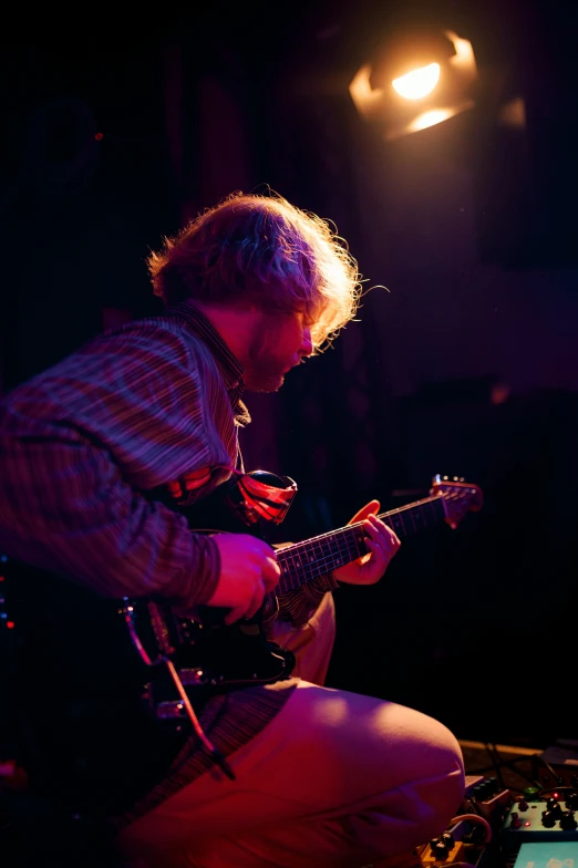 a man plays an electric guitar at a music festival