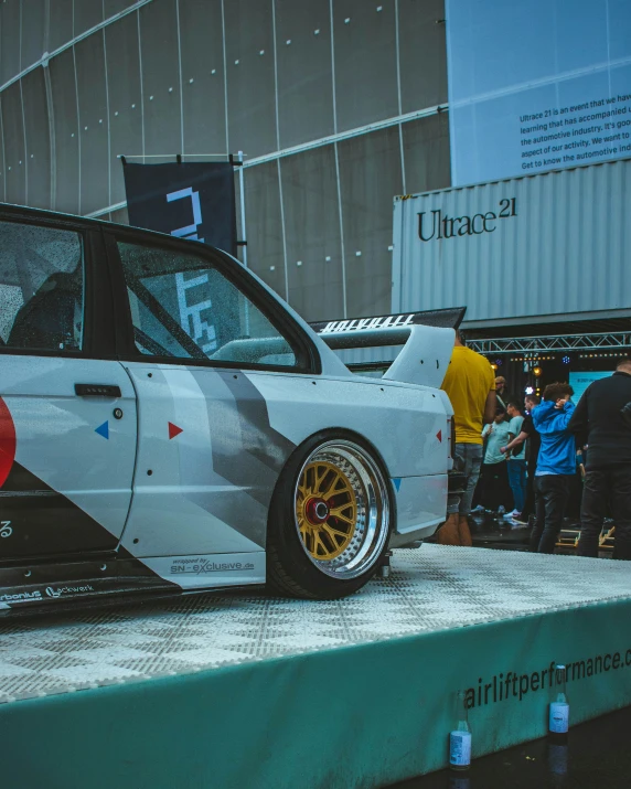 a white car that is on display at a show