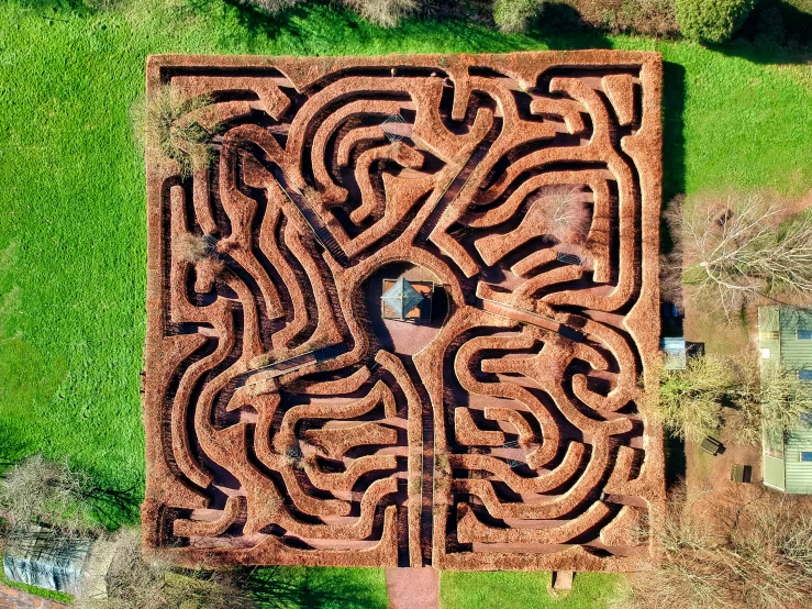 the design of an aerial view shows the circular maze, in which a smaller group of people are seen looking at the camera