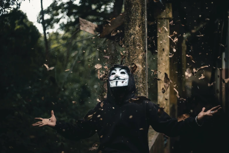 man with a mask on posing in front of tree