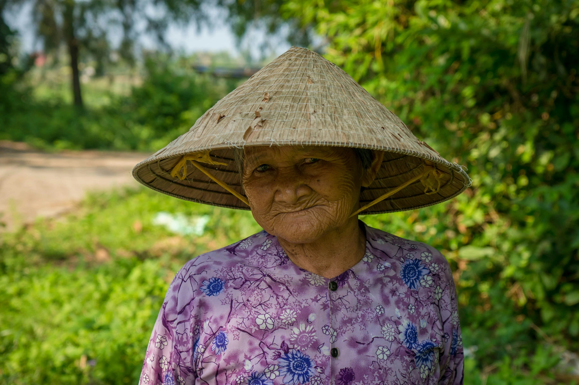 a woman wearing a straw hat in the grass