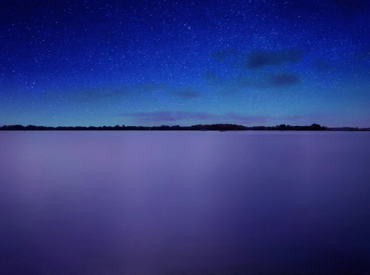 the night sky with stars above the ocean