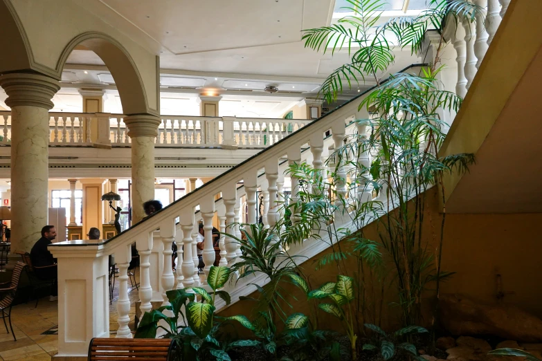 large hallway with planters at bottom and two people in background