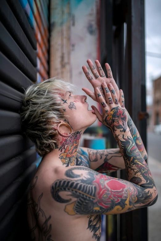 a person with tattoos looking through a window