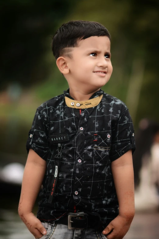 a little boy wearing a black shirt and a bib